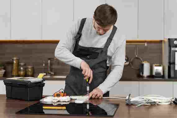 Technician repairing a refrigerator in an Augusta home
